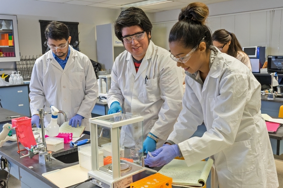 citrus college biotechnology students conduct laboratory work while wearing protective eyewear, gloves and lab coats