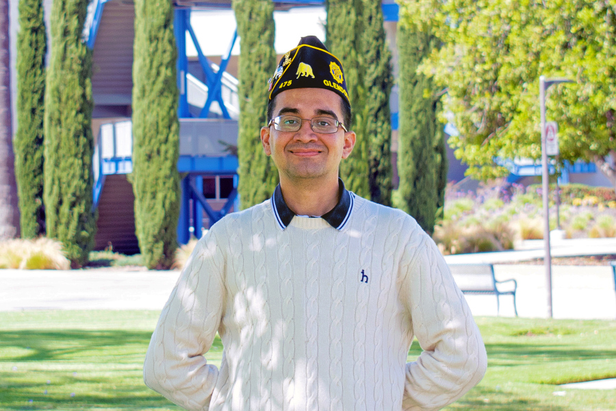 Hector Pimienta Jr. on campus woth the ED Building in the background