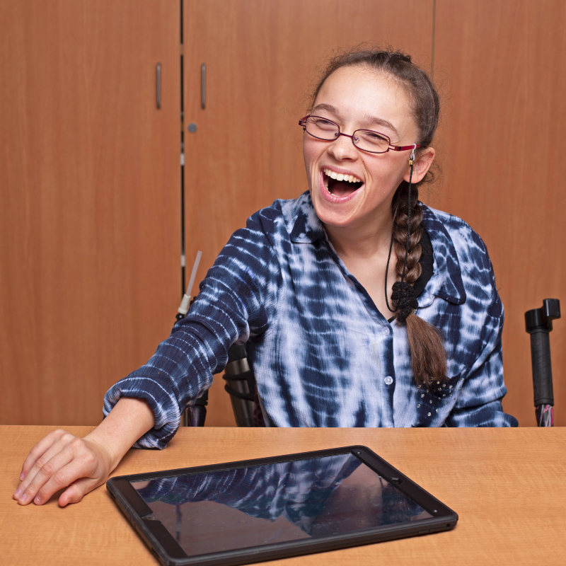 a smiling Elina Hughes poses with her iPad; photo courtesy Daniel Escamilla